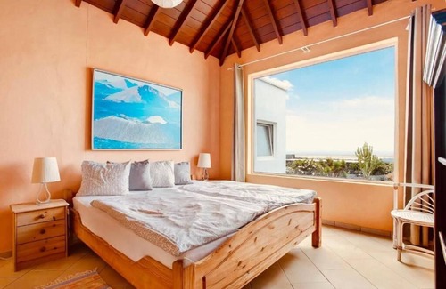 Teguise Resort | Apartment 1 with panoramic window in the bedroom facing the sea and Risco Famara