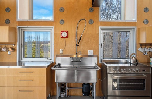 Northport House | Award-winning 9-level Chameleon House in Leelanau County. A modern-industrial masterpiece with reflective siding, rooftop deck, and epic Lake Michigan views near beaches and Fishtown.