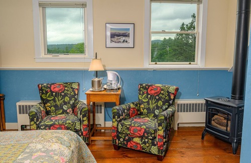 Stowe Bed & Breakfast | Comfortable room with queen bed, a stunning view of Mount Mansfield, sitting area and a parlor stove with full service breakfast included