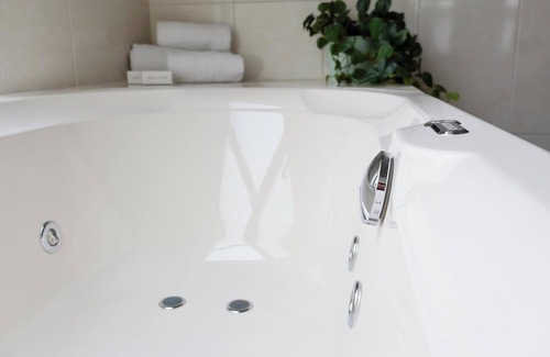 Appeltern Hotel | Deluxe hotel room with luxurious amenities, a duo whirlpool tub, and stunning water views for the ultimate relaxation.
