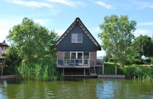 Makkum Cabin | Detached 8-person fisherman's villa with a patio above the water and a private jetty at Beach Resort Makkum on the IJsselmeer.
