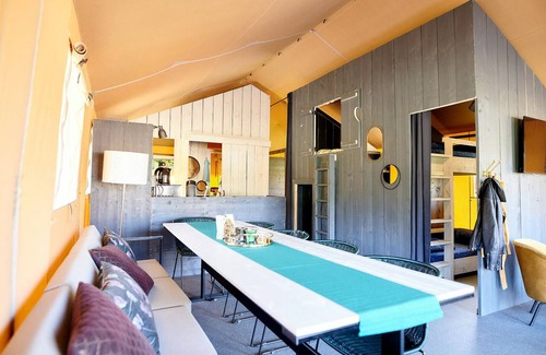 Nieuw Heeten House | Enjoy the ultimate glamping experience in the Safaricottage XL for 8 people by the pond at Vakantiepark de Sallandshoeve, perfect for families and nature lovers.