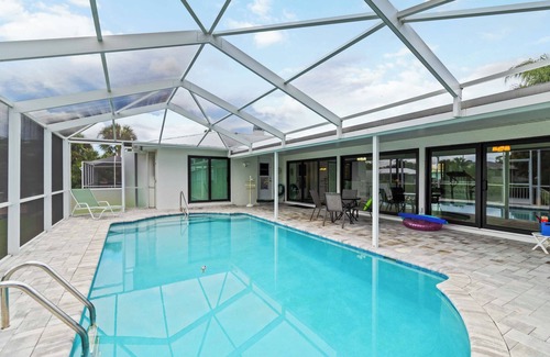 Port Charlotte House | Experience serenity in this fully furnished 3-bed, 3-bath waterfront home featuring a heated pool, spacious layout, and abundant natural light. Enjoy stunning water views from the master suite, living room and Florida room.