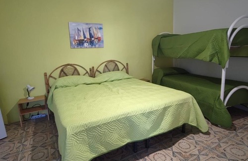 Stromboli Villa | Green room with 4 beds, bathroom and patio with equipped kitchen
