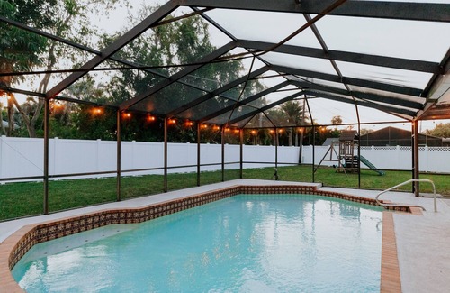 Palma Sola House | LUXE beach getaway 5mins from water. 3xKING BR, large heated pool + new playland