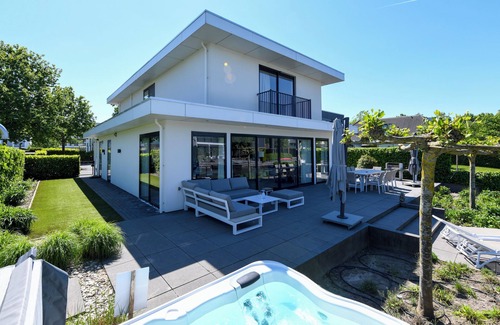 Zeewolde House | Luxury 10-person villa with jacuzzi, sauna, 4 bedrooms, 3 bathrooms and two outdoor dining tables. Pet-friendly, fully equipped kitchen, and direct water access.