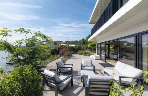 Zeewolde House | Luxury 6-person villa with private infrared sauna, outdoor shower, balcony with water views and sunny fenced garden with private dock. Located at Villa Resort Harderwold.