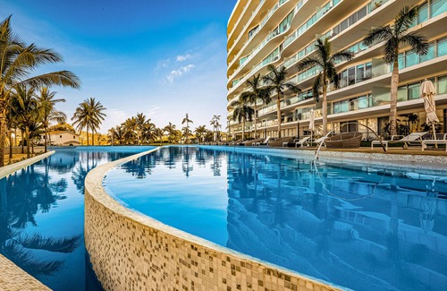 Flamingos Condo | Luxury ocean-view condo with resort pool, private balcony, and washer/dryer