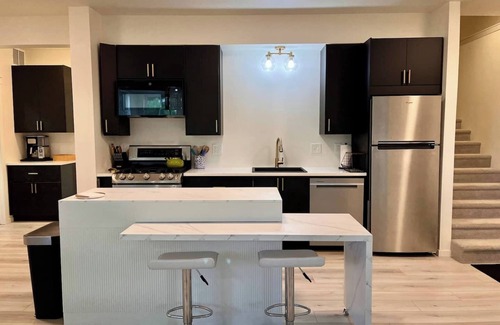 Loveland House | Nestled on the Marianna Butte Golf Course in Loveland, this modern garden-level basement retreat offers stunning mountain & lake views through large windows, flooding the space with light. Just a short drive to CSU campus & Estes Park