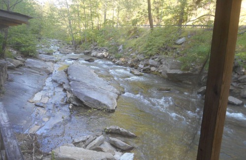 Bat Cave Cottage | On the River's Edge! Rocking chairs on large screened porch on river's edge.