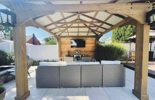 Baldwin Harbor Apartment | Poolside play with a relaxing hot tub, fire pit, & gazebo with a television.