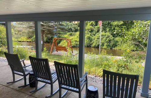 Grayling House | Riverfront Escape in Downtown Relax on the Covered Patio with the Family