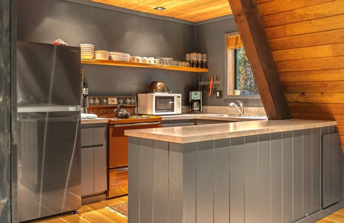 Rhododendron Cabin | Riverside A-frame in gated cabin community with private deck, woodstove, & W/D