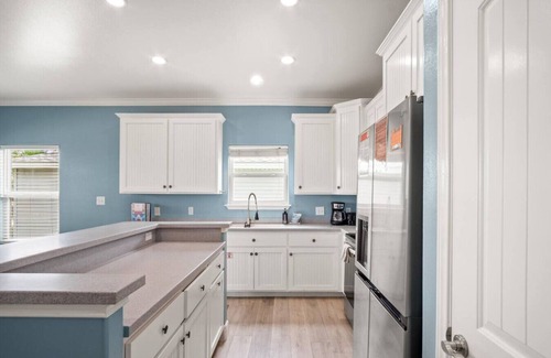 Leeward Sands House | "Step into Shark Attacks and embrace the coastal charm, setting the scene for a refreshing escape. With a spacious open floor plan, it's perfect for family gatherings and unforgettable memories."
