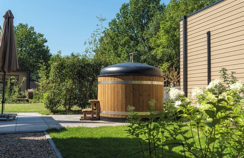 Lieren House | Stylish 6-person home with three bedrooms, a modern kitchen, air conditioning, and a cozy outdoor space with a luxury pergola and private hot tub. Enjoy comfort and nature in the Veluwe.