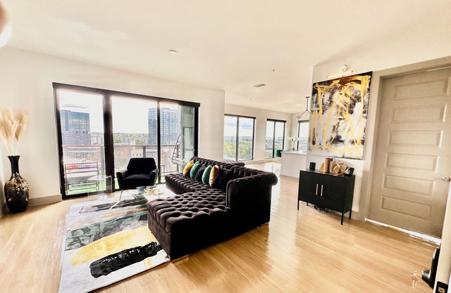 Ceiling to floor windows featuring a private balcony with stunning city views! n
