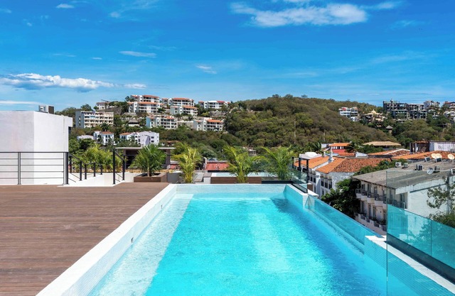 Cozy 1-bedroom condo with 4 rooftop pools, BBQ area only a minute to the beach!