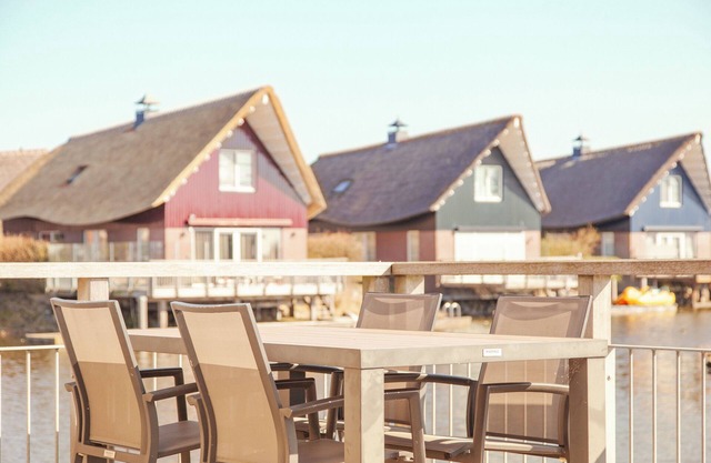 Detached fisherman's villa for 6 persons with a patio above the water, bathtub, and jetty at Beach Resort Makkum in Friesland.