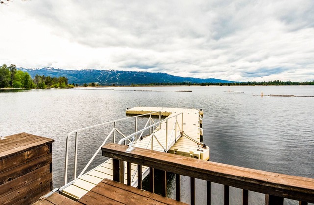 Dreamy waterfront oasis with fireplace, firepit, patio, dock, and mountain views
