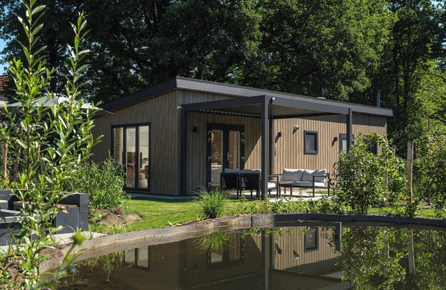 Enjoy a luxurious holiday home for 4 people in the wooded nature of the Veluwe, complete with modern amenities, air conditioning, and a stylish pergola for optimal comfort. Additionally, unwind in the private hot tub, perfect for relaxing after a day