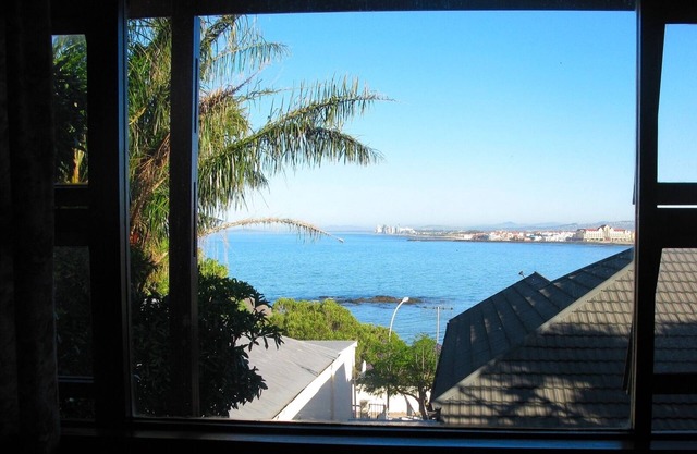 Sunny, open-plan family home, above sunset beach, with sea and mountain views.