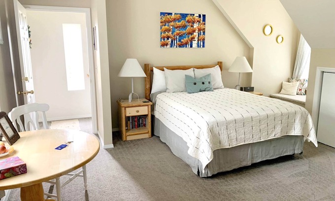 Bozeman House | Falls Queen Suite with vaulted ceilings, mountain views and property hot tub.