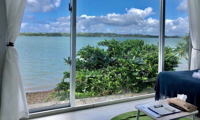 Nago Apartment | Indigo Ocean front Large windows overlook the se / Nago Okinawa