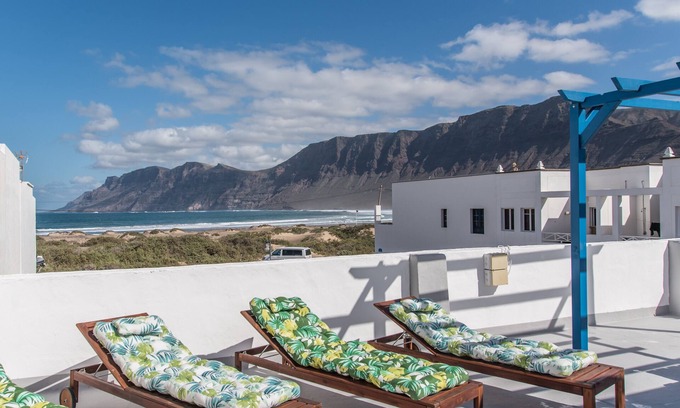 Caleta de Famara Apartment | Sandy Bay Home with roof terrace and sea views